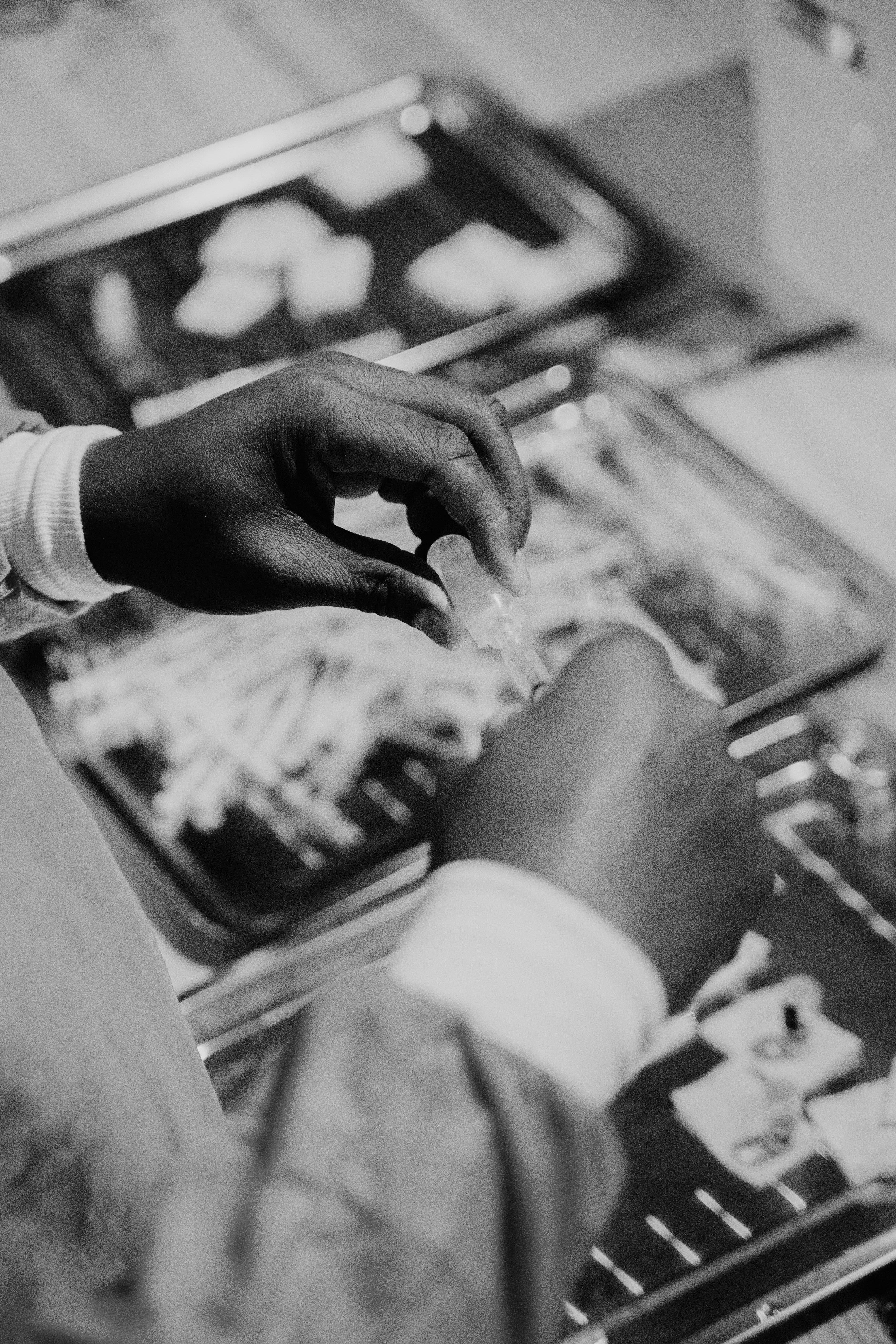 person in blue long sleeve shirt holding clear glass bottle